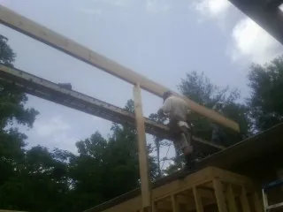 Carpenter setting a ridge beam over a new addition frame — Ice Dam Removal by Roofing Brothers in South Lancaster