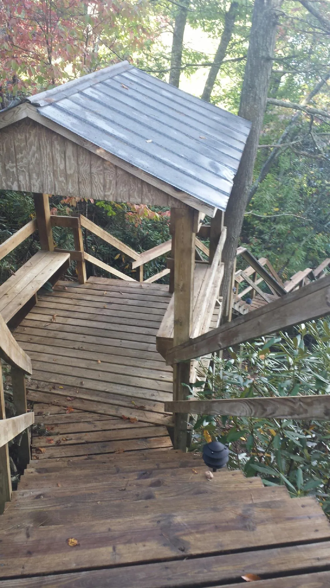 Metal roofed shelter over wooden steps on a wooded walkway — Skylight Repair & Installation work by our crew in South Lancaster