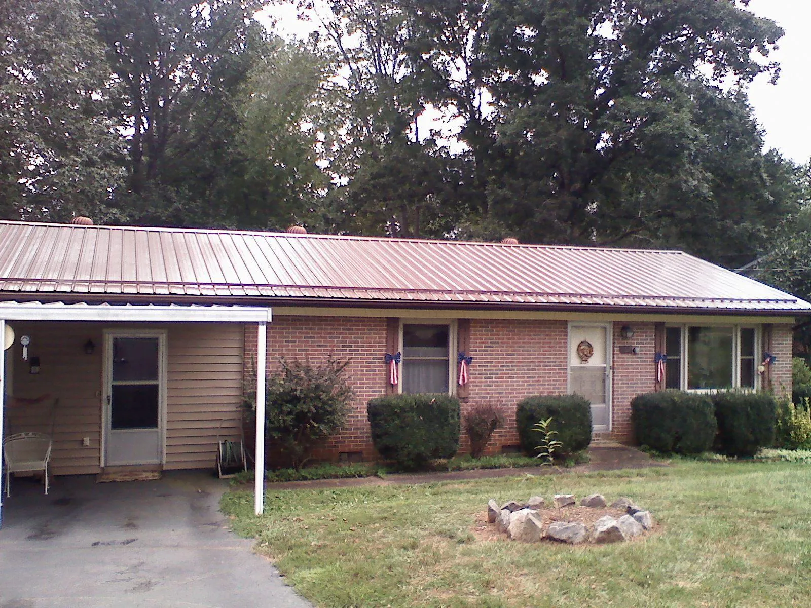Bronze metal roof and carport on a brick ranch home — Roof Repair work by our crew in South Lancaster